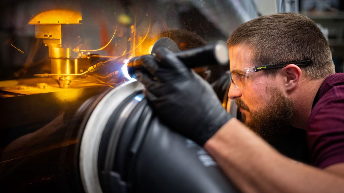 Sandia technologist Levi Van Bastian works to print material on the Laser Engineered Net Shaping machine, which allows scientists to 3D print new superalloys. (Photo by Craig Fritz)