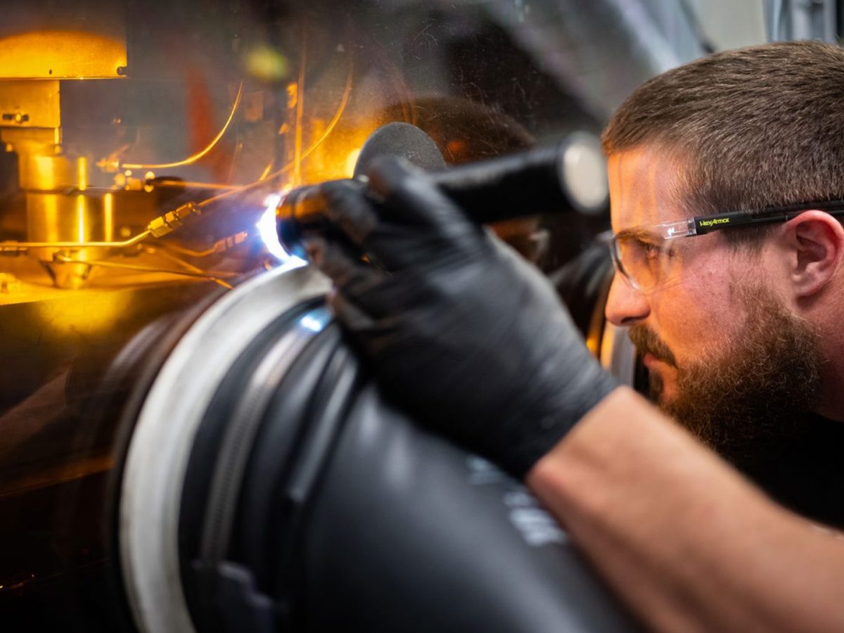 Sandia technologist Levi Van Bastian works to print material on the Laser Engineered Net Shaping machine, which allows scientists to 3D print new superalloys. (Photo by Craig Fritz)